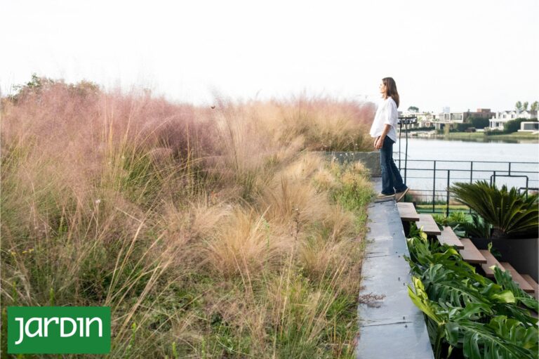 Jardín con terrazas y escaleras integradas en una pendiente, con vegetación y piedras naturales