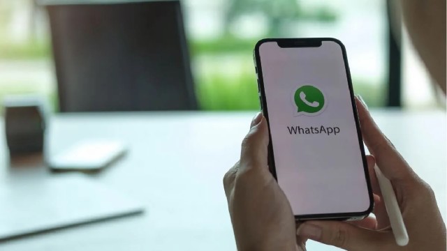 Persona utilizando un teléfono móvil con la aplicación WhatsApp abierta, mostrando una nota de voz en pantalla.
