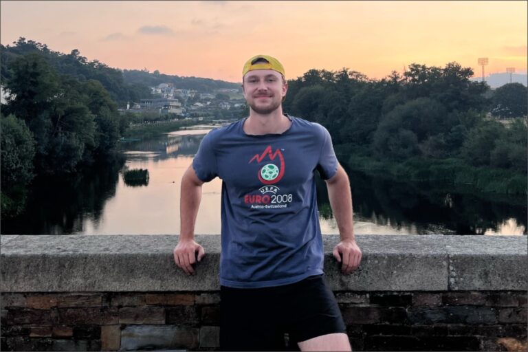 Joven estadounidense sonriente en un paisaje verde típico de Galicia, España.