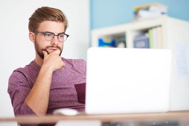 Persona analizando diferentes rankings y listados en múltiples pantallas de computadora