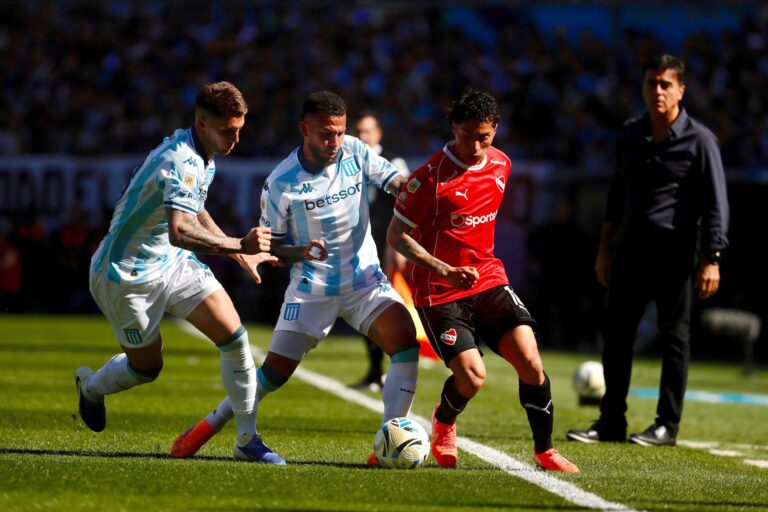 Los escudos de Independiente y Racing, separados por un balón de fútbol, sobre un fondo neutro.