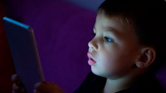 Niño usando Kids Sapiens en una tablet, con juegos educativos de razonamiento y memoria