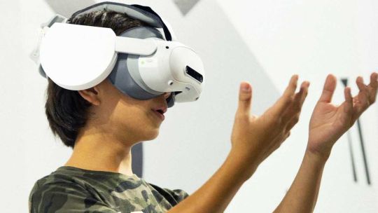 Persona con visor de realidad virtual recorriendo una reconstrucción medieval de Carcassonne
