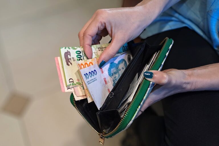 Familia revisando cuentas y facturas en una mesa de cocina, signos de preocupación financiera
