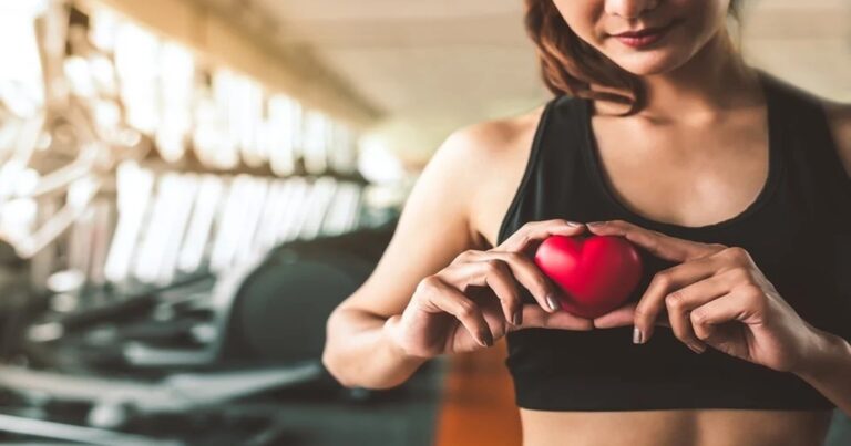 Persona realizando ejercicio en una máquina de remo en un gimnasio.