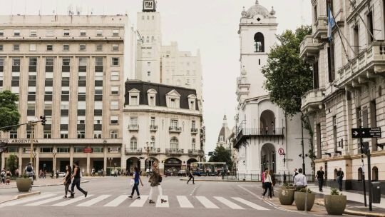 Café porteño con mesas y sillas en la vereda