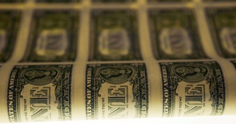 Billetes de dólar estadounidense y pesos argentinos sobre una superficie