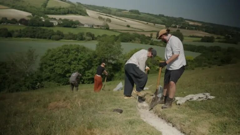 Voluntarios colocando tiza en el contorno del Gigante de Cerne Abbas en una colina del sur de Inglaterra