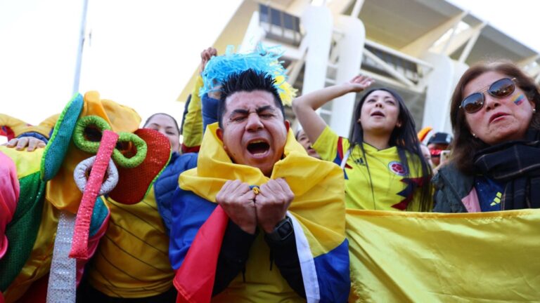 Estadio de fútbol con banderas y aficionados durante un partido del Mundial