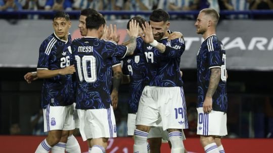Balón de fútbol sobre césped con banderas de países clasificados al Mundial 2026